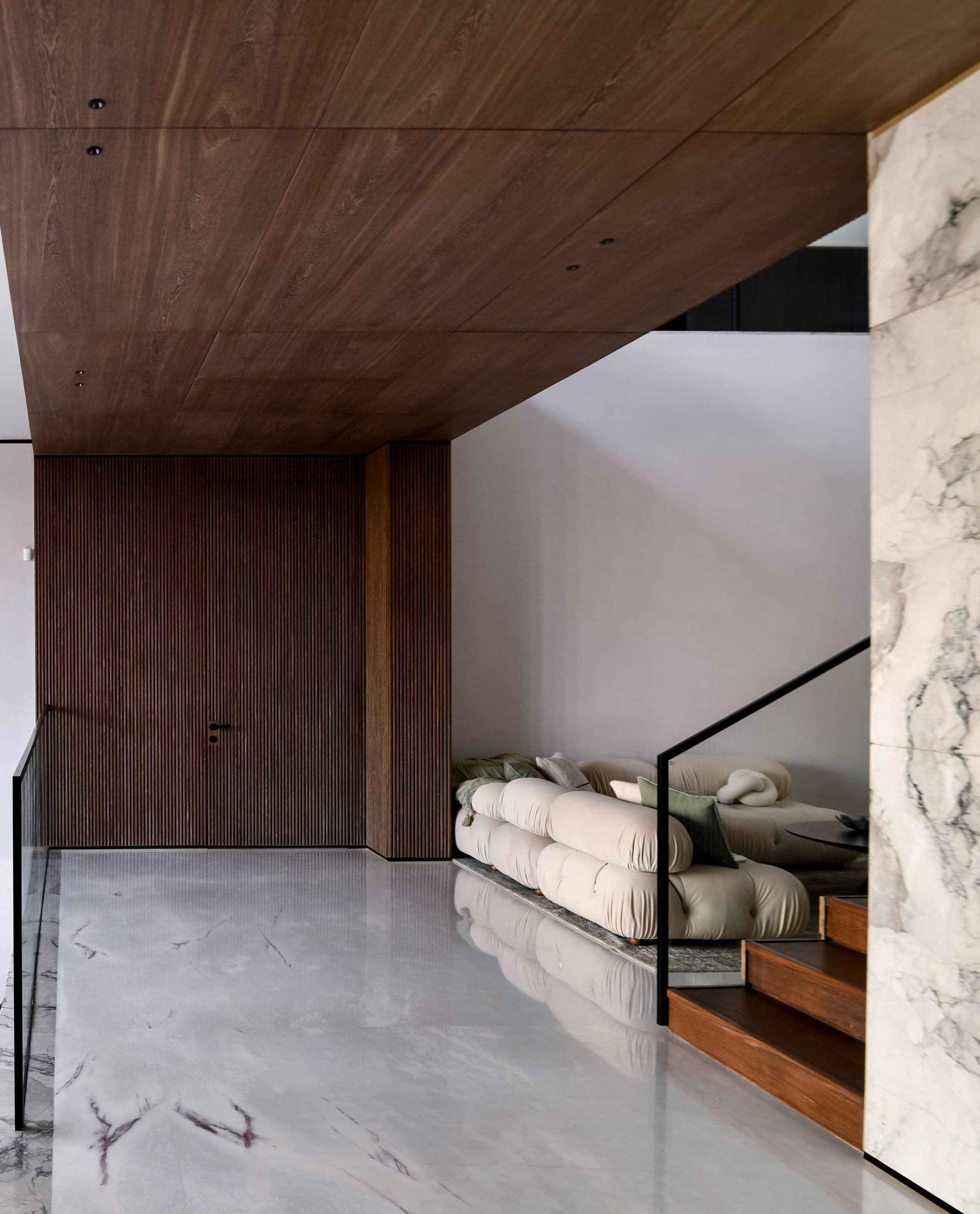 Marble hallway overlooking a cream modular lounge