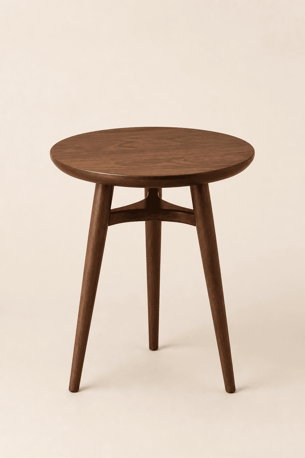Round walnut side table with tapered legs